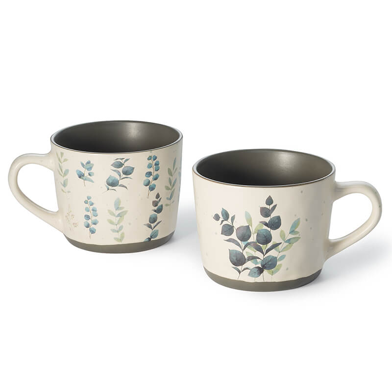 L'eucalipto è un trend in floristica e moda. Questa tazza in ceramica da 0,35 l, con foglie di eucalipto e dettagli eleganti, è perfetta per tè, caffè o cioccolata. Il manico ergonomico la rende comoda e pratica per l'uso quotidiano.
